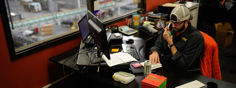 Joe Simmons talks on the phone at his desk on Tuesday, Jan. 12, 2016, at SweetWater Brewing Company in Atlanta, Ga. (AJ Reynolds for The Brewer Magazine)